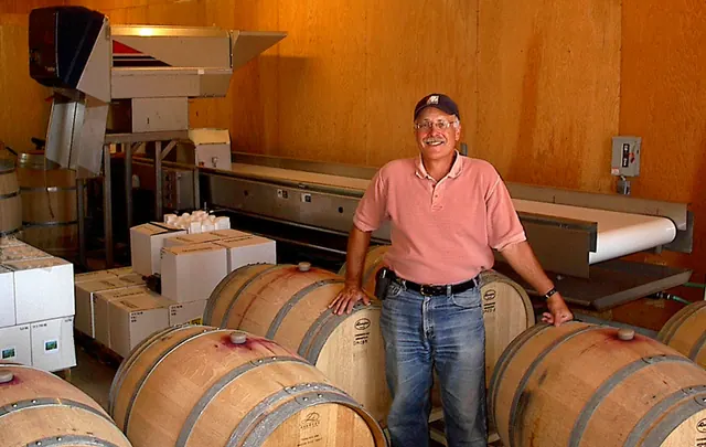 Randle Johnson standing among wine barrels